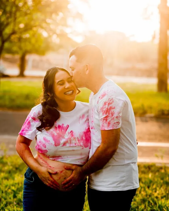 Casal em ensaio de gestante ao pôr do sol